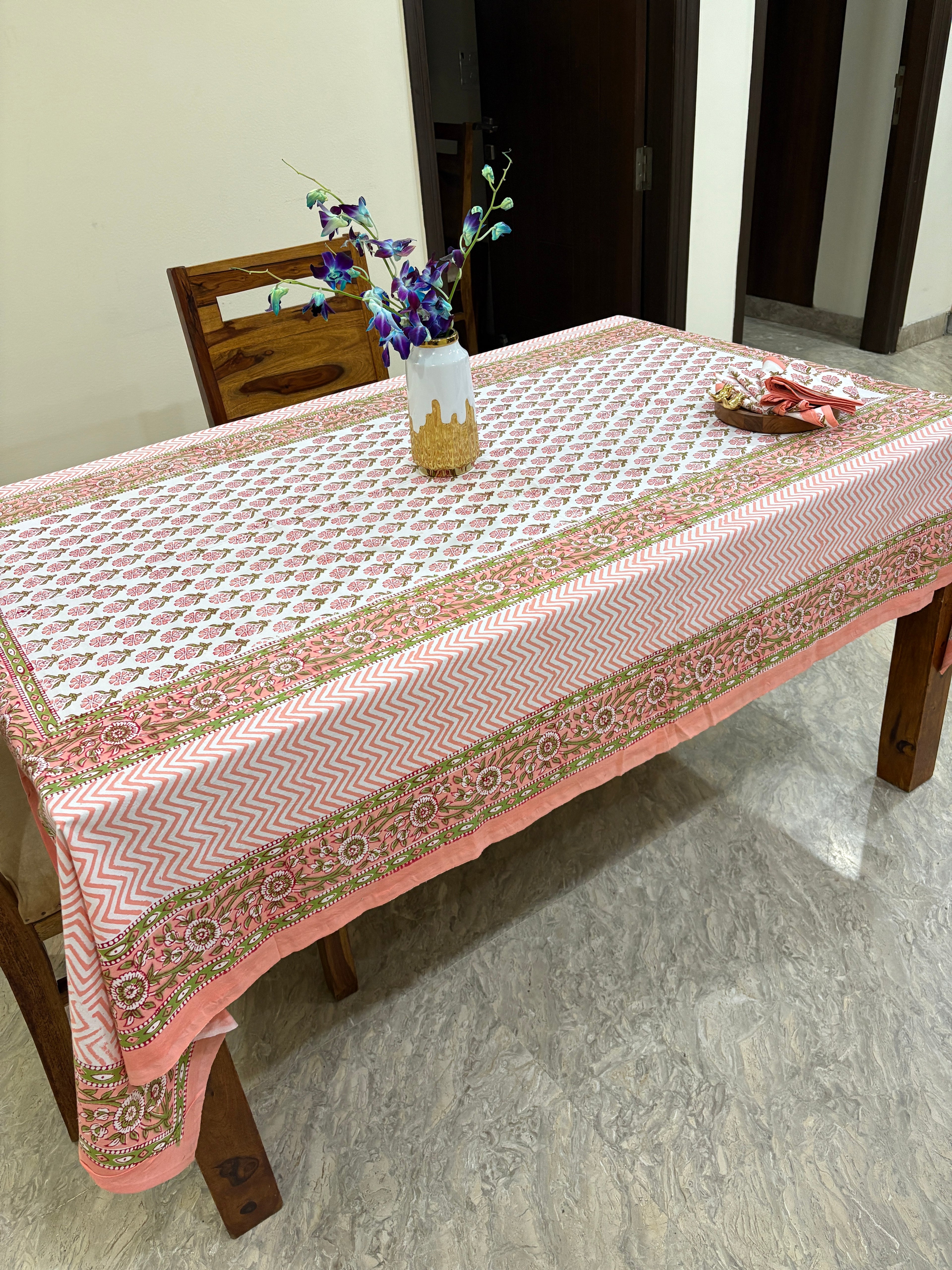 Pink and white patterned tablecloth on a wooden table.