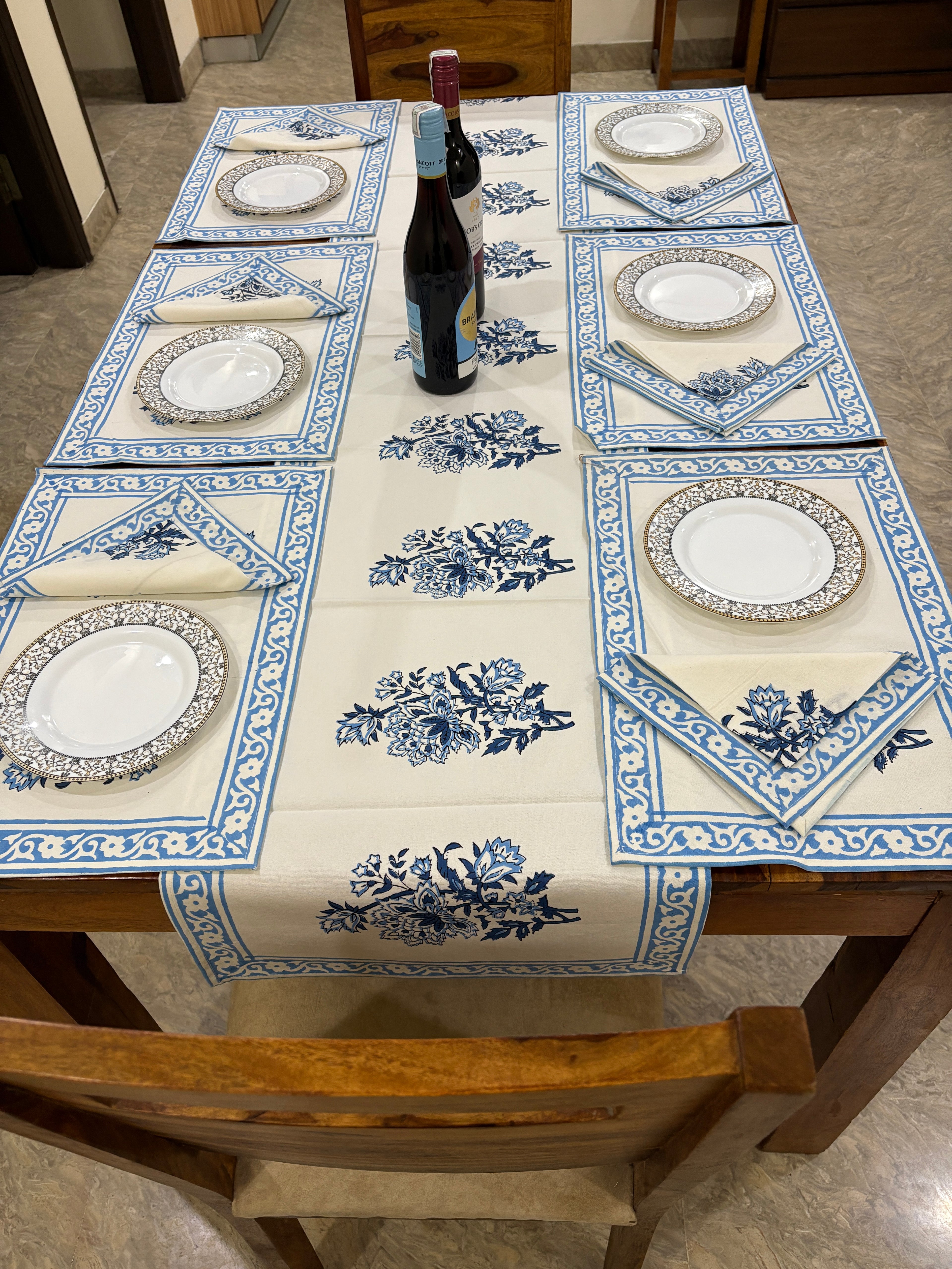 Decorative tablecloth with blue and white patterns on a wooden table.
